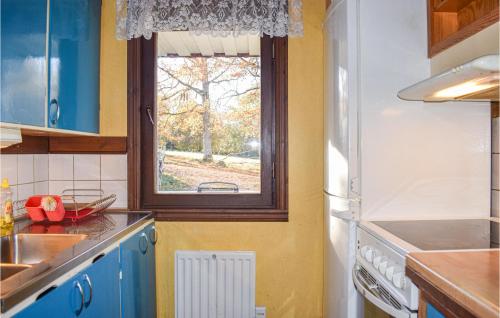 a kitchen with blue cabinets and a window at Two-Bedroom Holiday Home In Lammhult in Lammhult