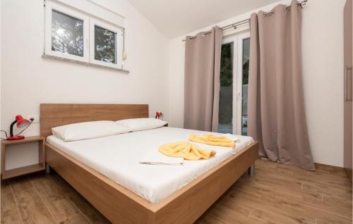 Schlafzimmer mit einem Bett mit weißer Bettwäsche und einem Fenster in der Unterkunft 1 Bedroom Gorgeous Apartment In Drvenik in Drvenik