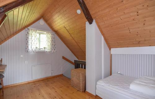 ムンケドルにあるGorgeous Home In Munkedal With Wifiの屋根裏のベッドルーム(ベッド1台、窓付)