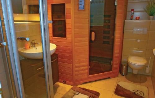 ein Bad mit einer Dusche, einem Waschbecken und einem WC in der Unterkunft Nice Home In Breege Ot Juliusruh With 2 Bedrooms And Sauna in Juliusruh