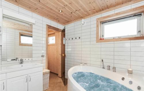 ein Badezimmer mit einer Badewanne und einem Waschbecken in der Unterkunft 3 Bedroom Beautiful Home In Rauland in Rauland