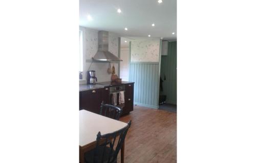 a kitchen and dining room with a table and chairs at Lovely Home In Gårdsjö With Lake View in Gårdsjö