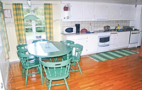 a kitchen with a table and chairs in a kitchen at Stunning Home In Svenljunga With Wifi in Grannäs