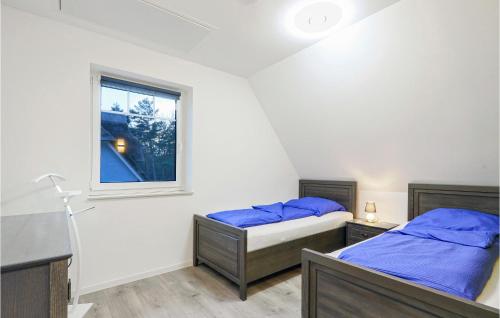 two beds in a room with a window at Reetdachhaus 26 Auf Usedom in Kutzow