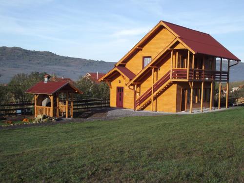 een groot houten huis met een tuinhuisje bij Korondi Kulcsosházak in Corund