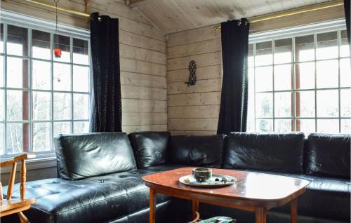 un soggiorno con un divano in pelle e un tavolo di Cozy Home In Kvinesdal With Sauna a Kvinesdal