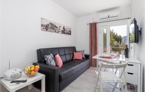a living room with a black couch and a table at Nice Apartment In Cres With Wifi in Cres
