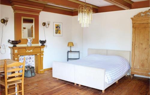 1 dormitorio con cama blanca y chimenea en Cozy Home In Visvliet With Kitchen, en Visvliet