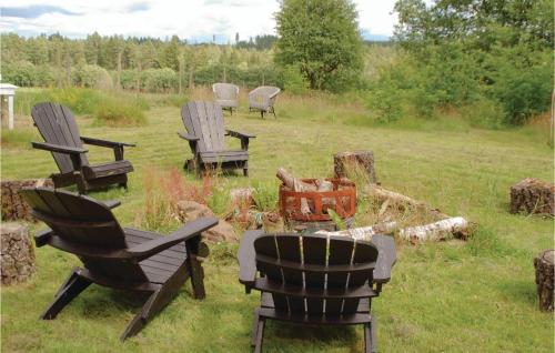 a group of chairs sitting in the grass at 3 Bedroom Awesome Home In Mårdaklev in Mårdaklev