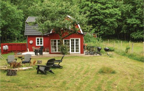 a small red house with chairs in the yard at 3 Bedroom Awesome Home In Mårdaklev in Mårdaklev