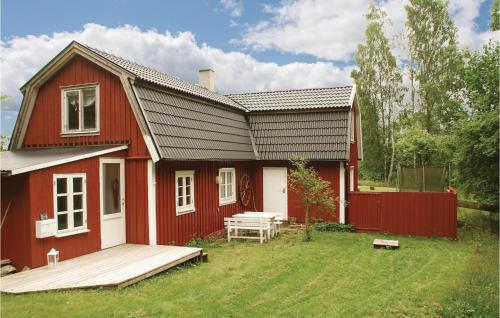 a red house with a picnic table in front of it at 3 Bedroom Awesome Home In Mårdaklev in Mårdaklev