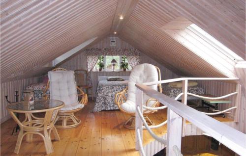 a attic room with chairs and a table and a bed at 3 Bedroom Awesome Home In Degeberga in Degeberga