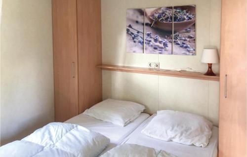 a room with two beds and a picture on the wall at 2 Bedroom Stunning Home In Tzummarum in Tzummarum