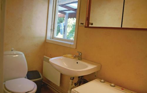 a bathroom with a sink and a toilet and a mirror at Lovely Home In Örkelljunga With Wifi in Drakabygget