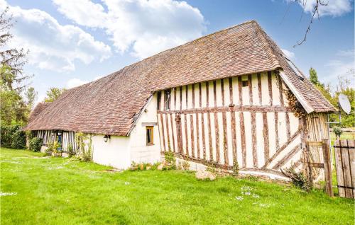 an old barn in a field of green grass at Amazing Home In St Pierre En Auge in Vieux-Pont-En-Auge