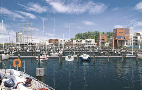 Un grupo de barcos atracados en un puerto con edificios. en Priwallpromenade 31, Whg 21, en Priwall