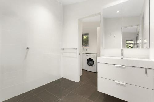 a white bathroom with a sink and a washing machine at Bungoona in Apollo Bay