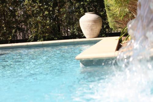 a swimming pool with a vase sitting next to a pool at Springfield Lakes Boutique Hotel in Springfield Lakes