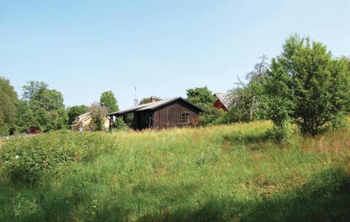 a field of grass with a barn in the background at 2 Bedroom Cozy Home In Hamneda in Hamneda