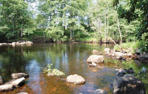 a river with rocks in the water and trees at 2 Bedroom Cozy Home In Hamneda in Hamneda