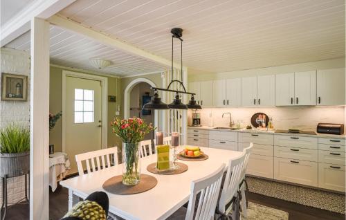 a kitchen with a table with a vase of flowers on it at Cozy Home In Hjo With Wifi in Hjo