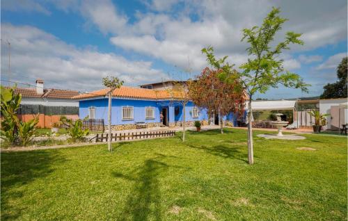 una casa blu in un giardino con un albero di Lovely Home In Guillena With Wifi a Guillena