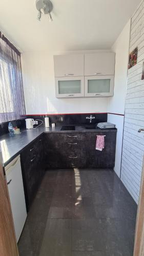 a kitchen with a black and white counter top at Apartament Centrum Arma Plac Rodła in Szczecin