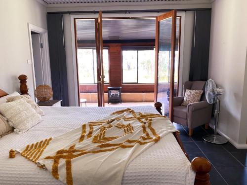 a bedroom with a large bed with a blanket on it at Peacehaven Chalet on the Irwin Inlet in Bow Bridge