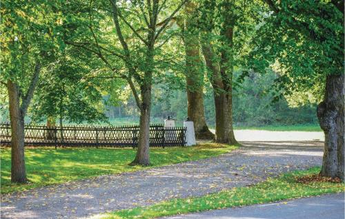 a path in a park with trees and a fence at Nice Home In Mantorp With Wifi in Mantorp
