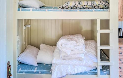 two bunk beds with white sheets and pillows on them at Strandbu in Vråliosen