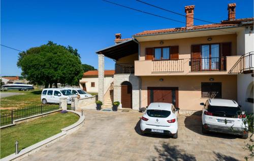 two cars parked in a parking lot in front of a house at Holiday Home Dobrani Cr in Rebići