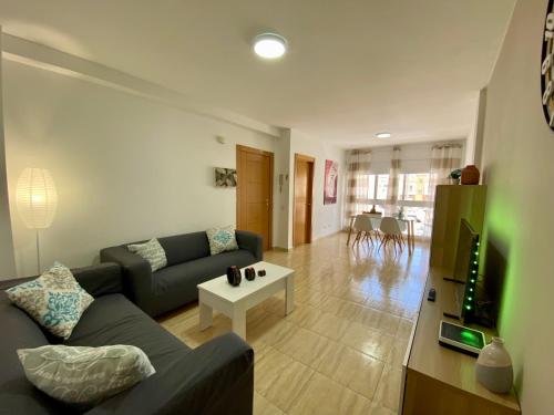 een woonkamer met een bank en een tv bij Casa Paty Fuerteventura in Puerto del Rosario