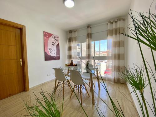 een eetkamer met een glazen tafel en stoelen bij Casa Paty Fuerteventura in Puerto del Rosario