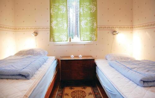 two twin beds in a room with a window at 2 Bedroom Beautiful Home In Örkelljunga in Drakabygget
