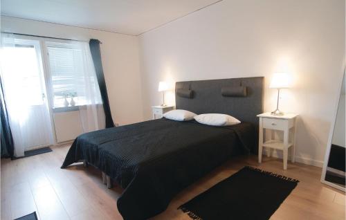 ein Schlafzimmer mit einem Bett mit einer schwarzen Bettdecke und einem Fenster in der Unterkunft Beautiful Apartment In Gotlands Tofta With 1 Bedrooms in Tofta