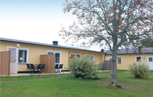 a yellow house with a table and chairs in a yard at Awesome Apartment In Gotlands Tofta in Tofta