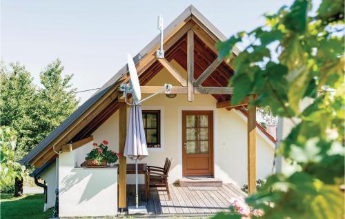 a house with an umbrella and a table and chairs at Ferienwohnung Eisenberg in Eisenberg an der Pinka