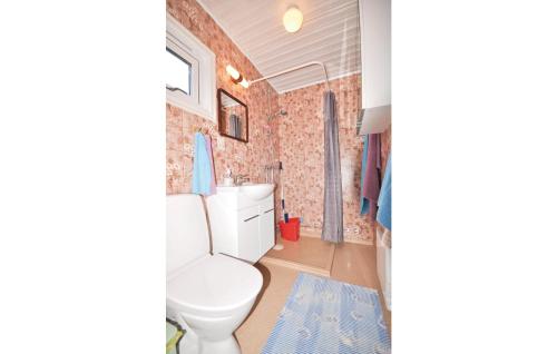 a bathroom with a white toilet and a brick wall at Stunning Home In Slvesborg With Kitchen in Hällevik