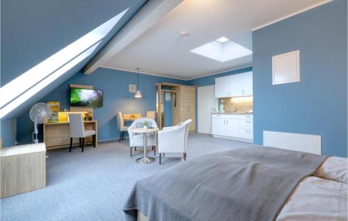 ダゲビュルにあるStunning Apartment In Dagebll With Wifiの青い壁のベッドルーム(テーブル付)、キッチン