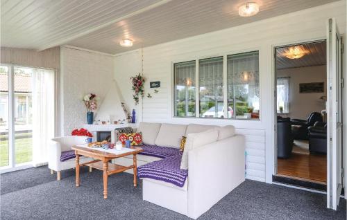 a living room with a white couch and a table at Holiday Home Skyttevägen Sölvesborg Ii in Hällevik