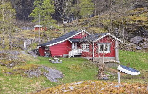 a red house with a boat in front of it at Beautiful Home In Nordtveitgrend in Haugen