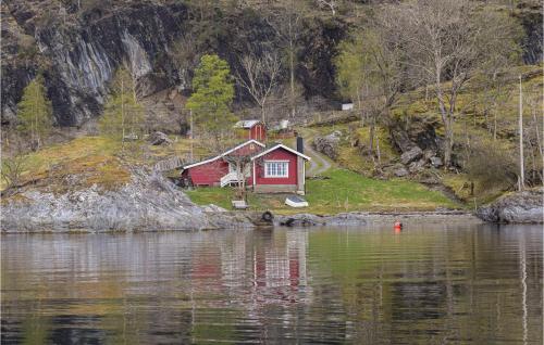 a red house on the shore of a body of water at Beautiful Home In Nordtveitgrend in Haugen