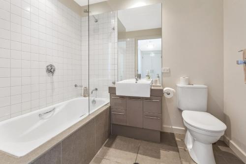 Un baño con inodoro, bañera y lavabo. en Point Grey Apartment 13, en Lorne