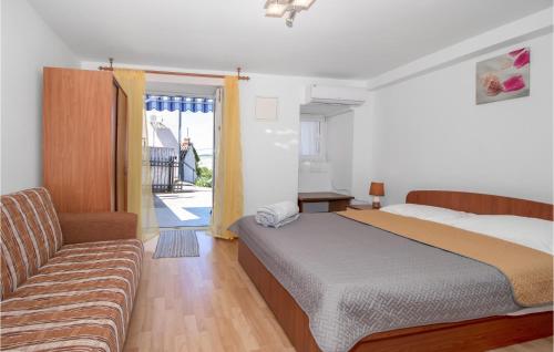 een slaapkamer met een bed en een bank bij Pet Friendly Apartment In Jadranovo With Wifi in Jadranovo