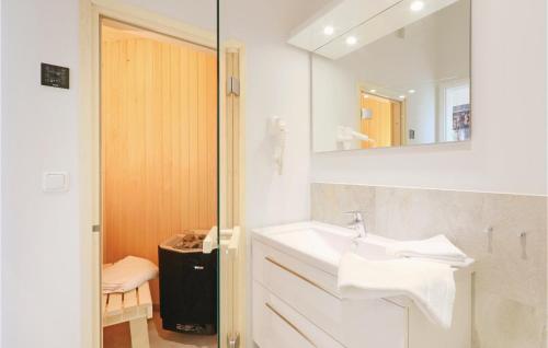 ein weißes Badezimmer mit einem Waschbecken und einem Spiegel in der Unterkunft Dnenvilla Penthouse in Travemünde