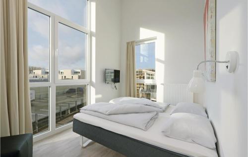 Bett in einem Zimmer mit einem großen Fenster in der Unterkunft Dnenvilla Penthouse in Travemünde