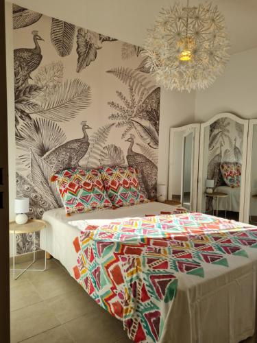 une chambre avec un lit avec une couette colorée dans l'établissement Entre Terre et Mer, à Roquebrune-sur Argens