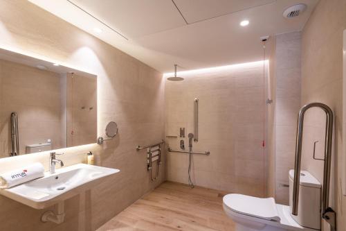 瓦伦西亚Apartamentos Core Suites Valencia的一间带水槽、淋浴和卫生间的浴室