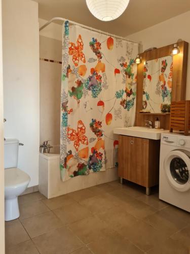 La salle de bains est pourvue d'un rideau de douche avec des papillons. dans l'établissement Entre Terre et Mer, à Roquebrune-sur Argens