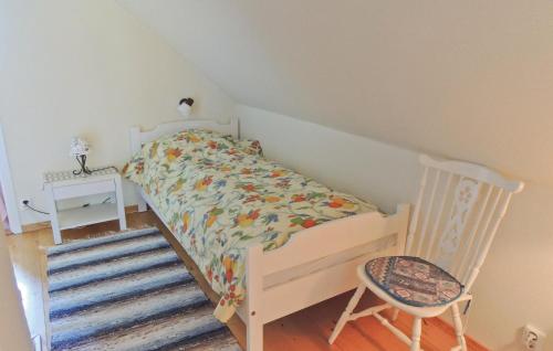 VessigebroにあるGorgeous Home In Vessigebro With Wifiの小さなベッドルーム(ベッド1台、椅子付)